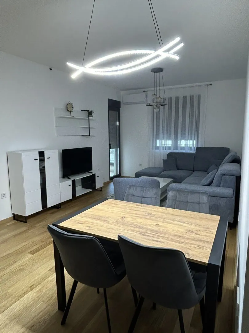 Svijetla dnevna soba sa trpezarijskim stolom i modernim namještajem.