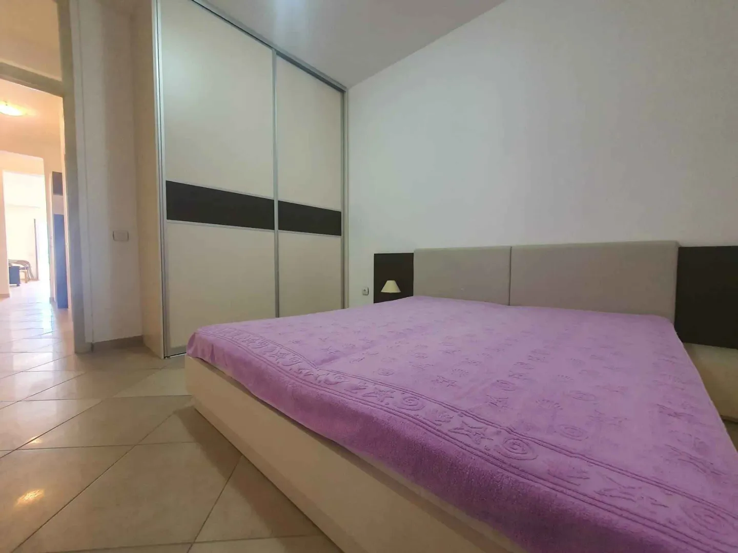 Spavaća soba sa bračnim krevetom i ugradnim ormarom.