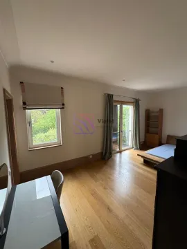 Spacious bedroom with wooden flooring, a bed, and a desk. - image 16
