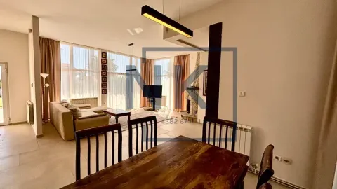 Spacious living room with a dining area and large windows. - image 16