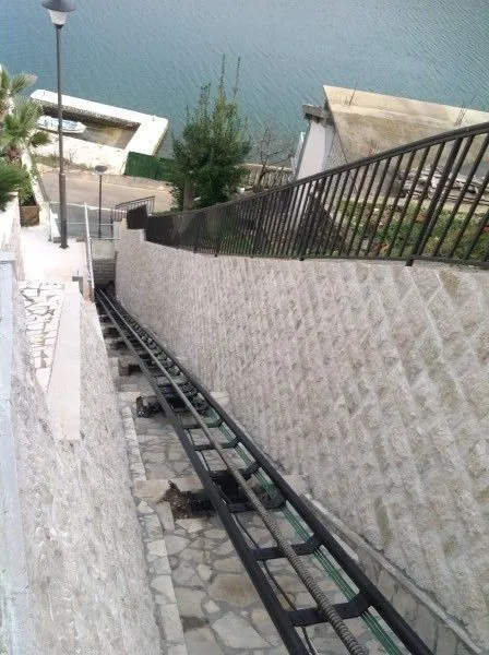 Privatni kosi lift sa kamenim zidovima koji vodi prema moru.