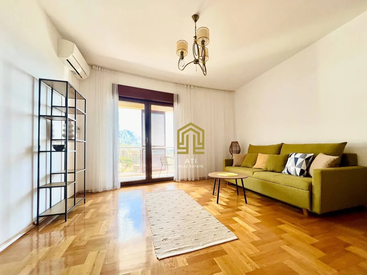 Living room with a sofa, parquet flooring, and access to the terrace.