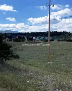 Pogled na prostrano zemljište sa drvenim stubom i okolnim pejzažem. - image 4