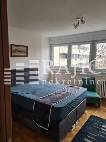 Furnished bedroom with a double bed and a window.