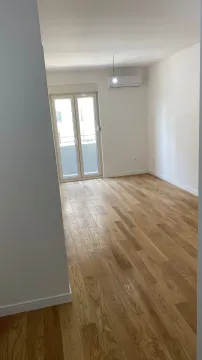 An empty room with light wood parquet, air conditioning, and access to a balcony. - image 5