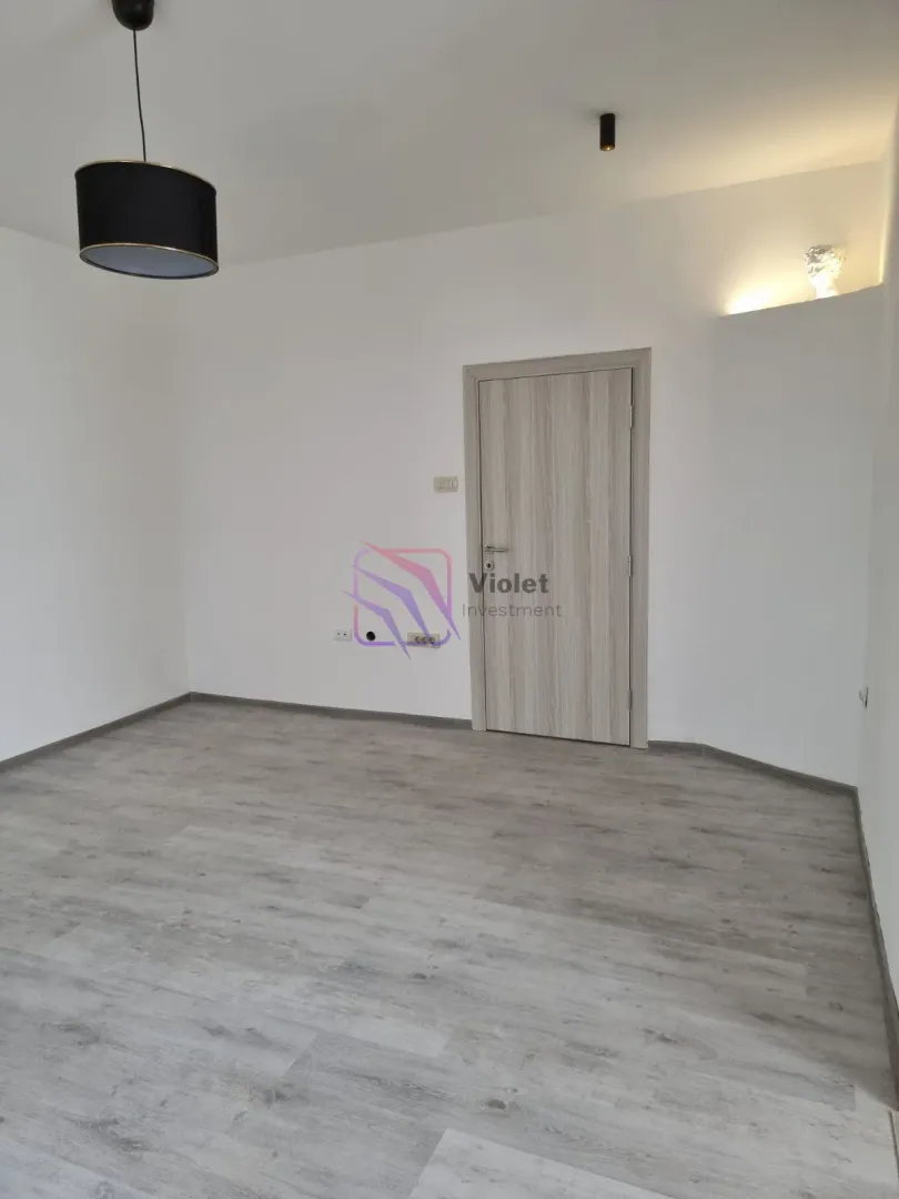Empty room with laminate flooring and a wooden door.