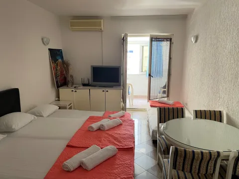 Furnished bedroom with beds, dining table, and access to the terrace. - image 4