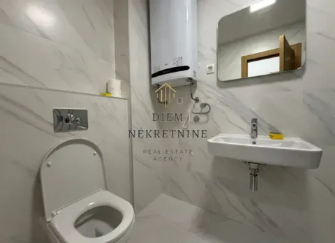 Moderno opremljeno kupatilo sa bijelim pločicama, wc šoljom, umivaonikom i bojlerom. - image 12