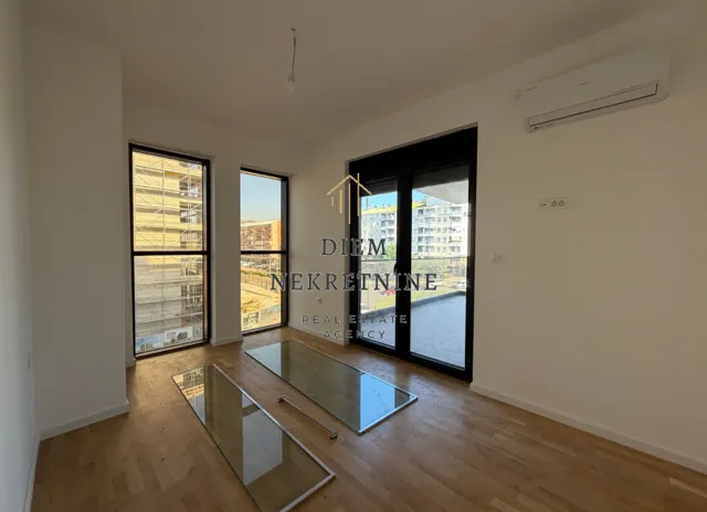 Empty bright room with wooden flooring and access to a terrace.