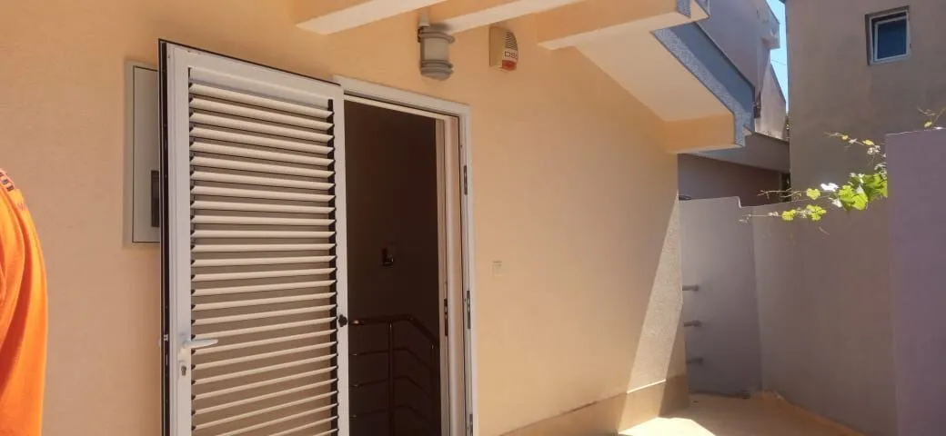Entrance to the house with white doors and shutters.
