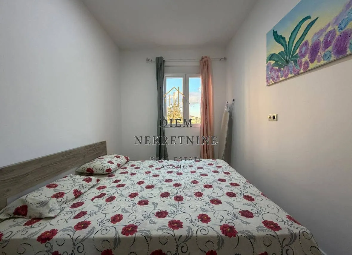 Furnished bedroom with a double bed and a window.