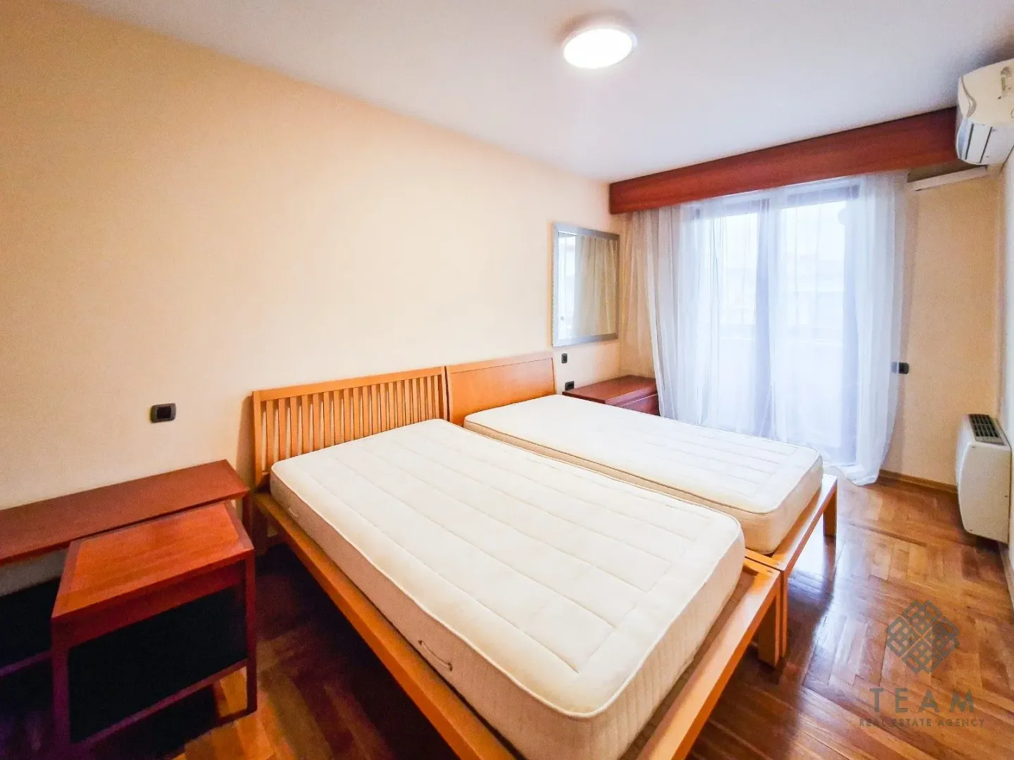 Bedroom with two wooden beds and access to the terrace.