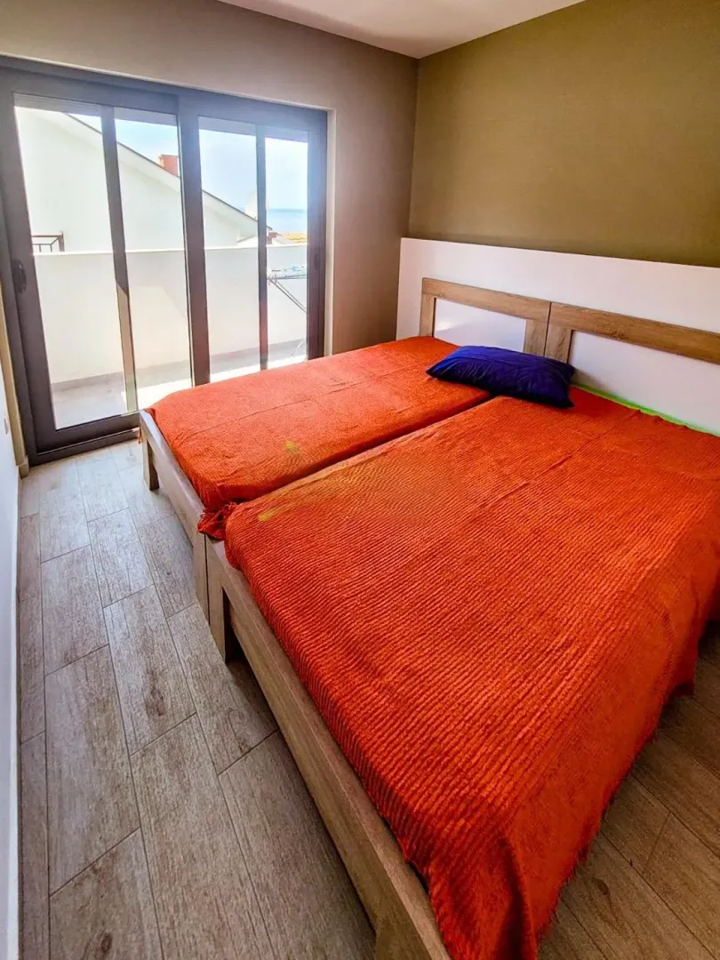 Spavaća soba sa bračnim krevetom i izlazom na terasu.