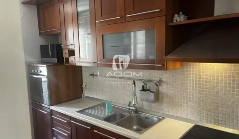 Kitchen with wooden cabinetry, sink, and built-in appliances. - image 6
