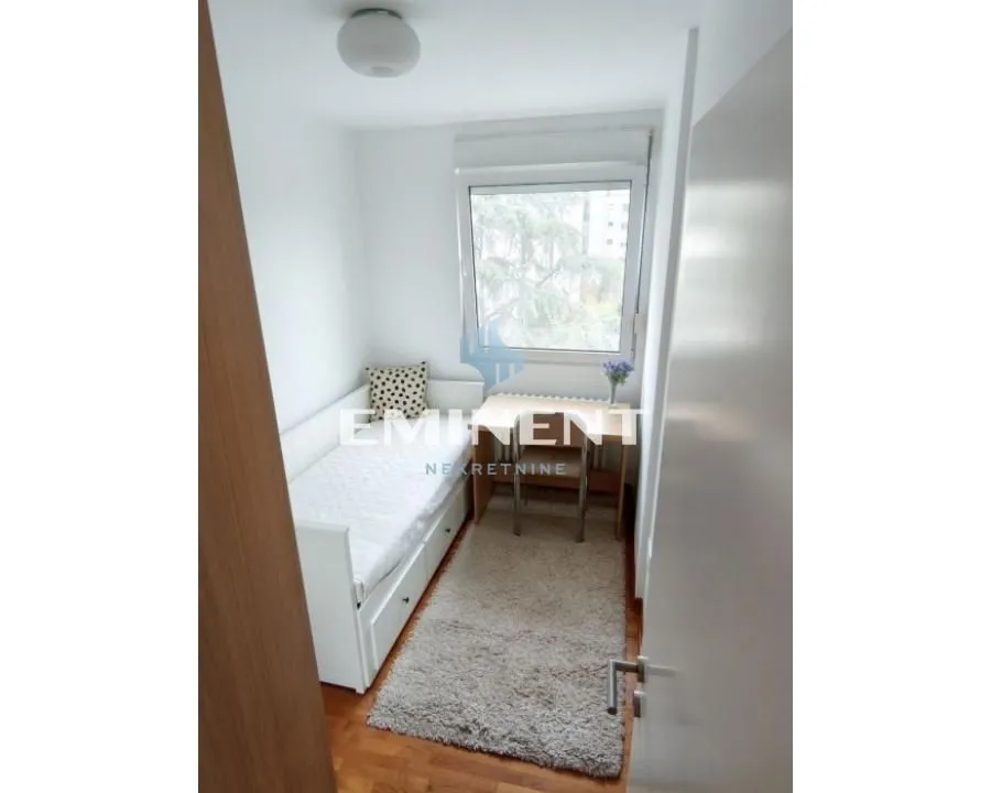 Small bedroom with a pull-out bed and a desk by the window.
