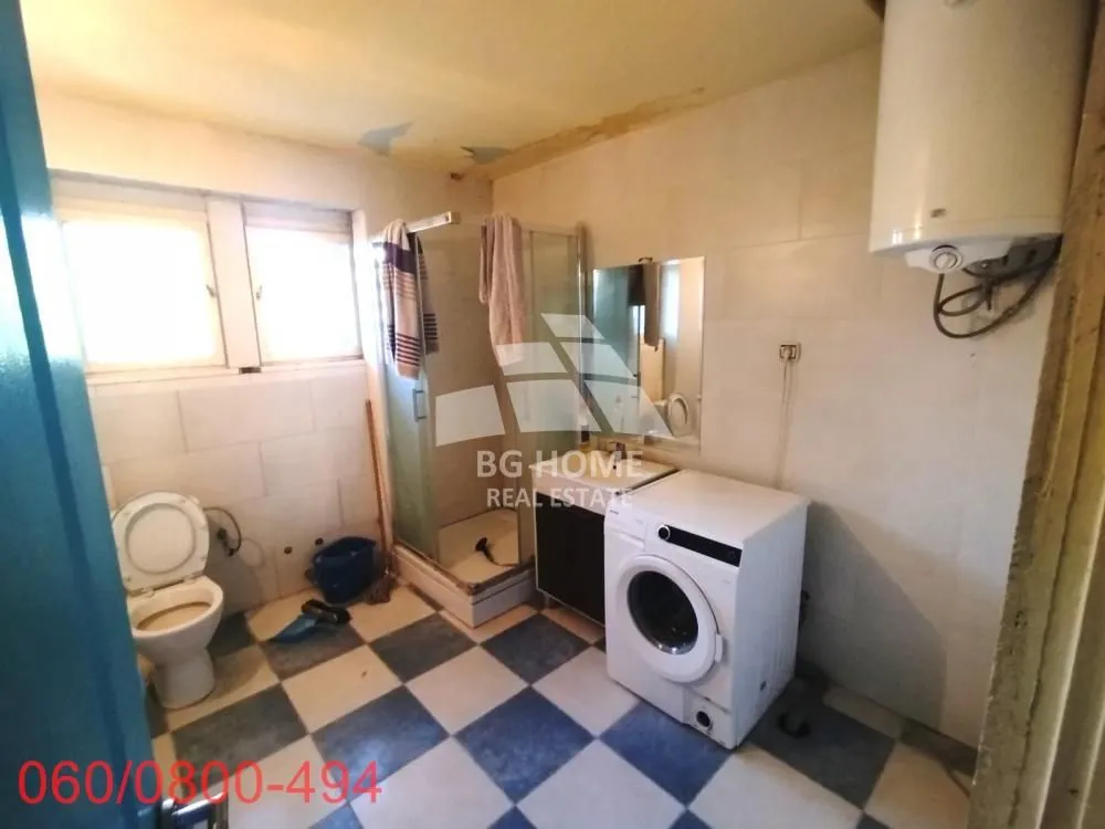 Kupatilo sa tuš kabinom, WC šoljom i veš mašinom.