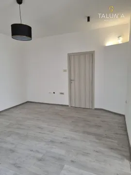 Empty room with light laminate flooring and a room door. - image 9