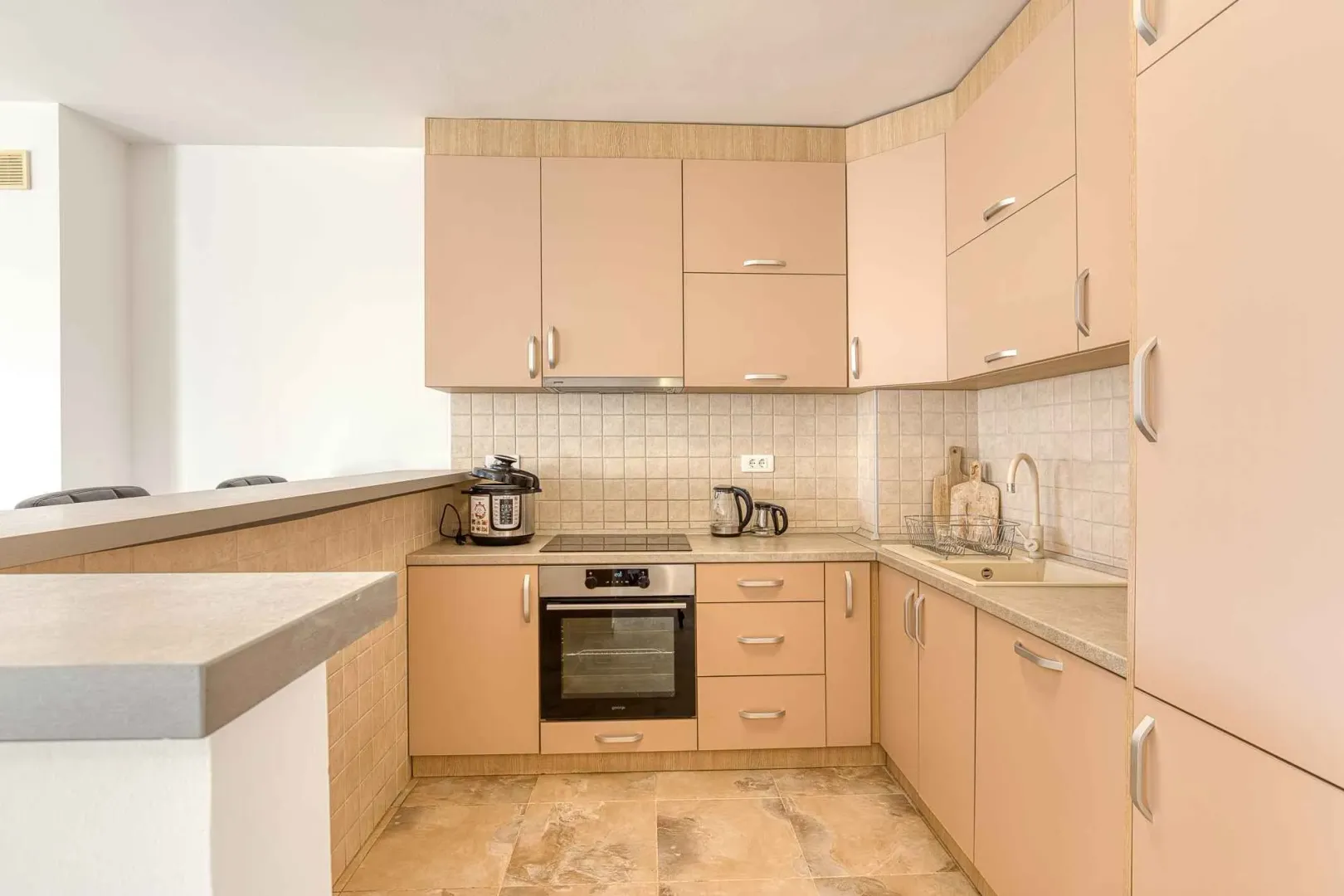 Kitchen equipped with wooden cabinetry, a stove, and a sink.