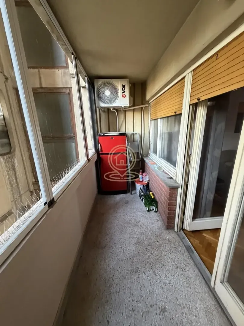 Zastakljeni balkon sa frižiderom i klima uređajem.