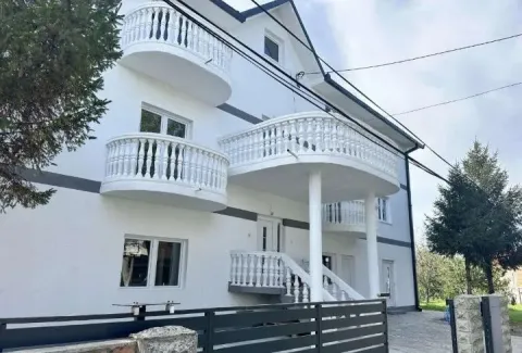 Eksterijer bele kuće sa više balkona i ogradom. - image 3