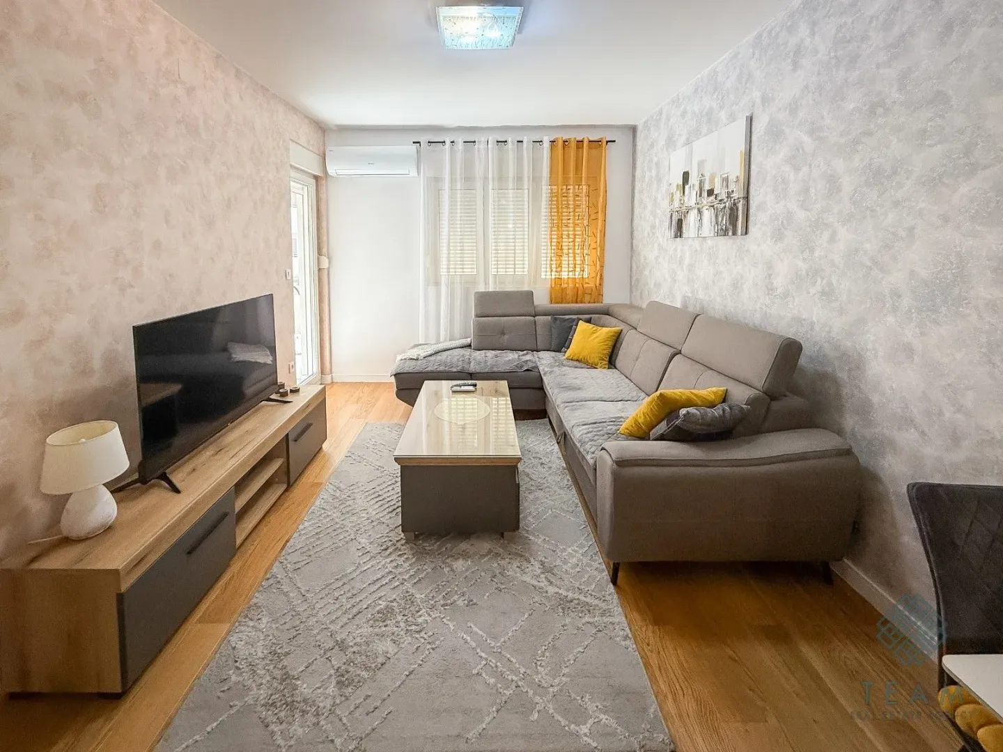 Living room with a corner sofa, television, and coffee table.
