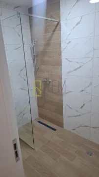 Savremeno opremljeno kupatilo sa tuš kabinom i keramičkim pločicama. - image 6