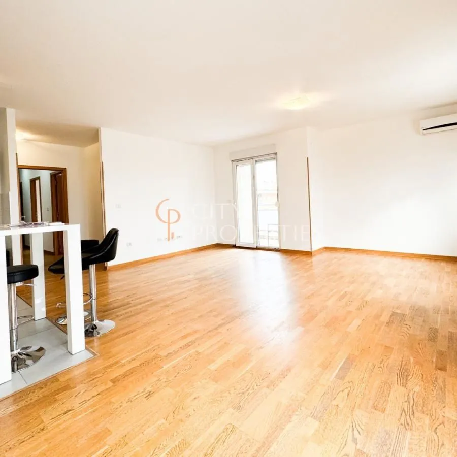 Spacious living room with wooden flooring and a breakfast bar with bar stools.