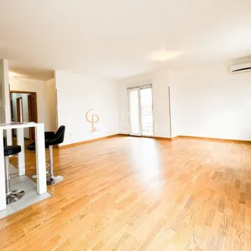 Spacious living room with wooden flooring and a breakfast bar with bar stools. - image 13