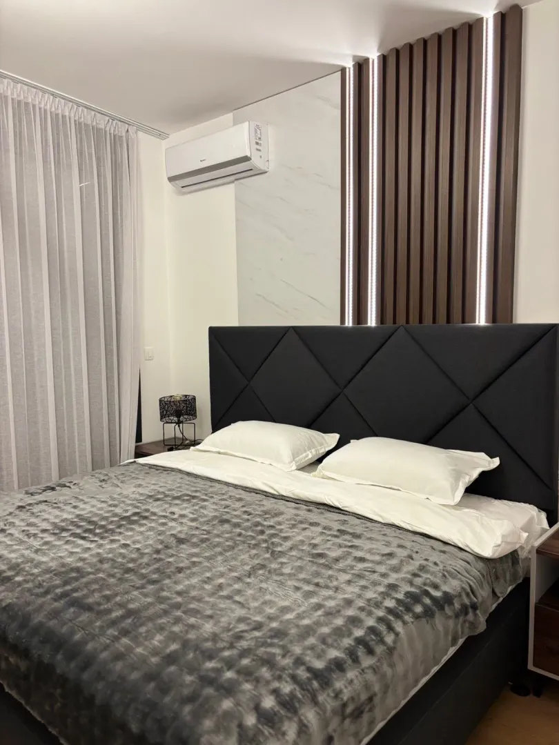 Modern bedroom with a large double bed and decorative wall panels.