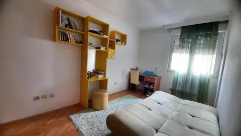 A bright room with yellow shelving, a desk, and a bed. - image 16