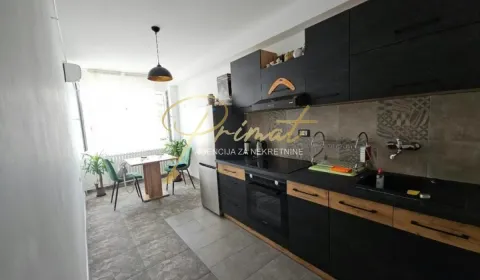 Dark-toned kitchen with a dining area by the window. - image 4