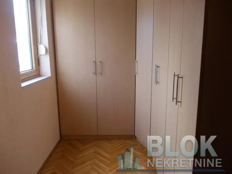Smaller bedroom with a built-in wardrobe and wooden flooring.