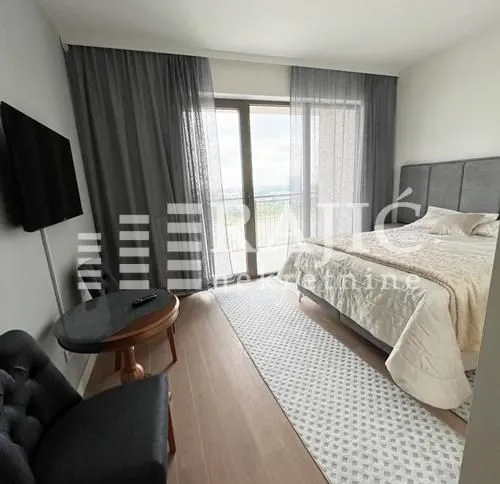 Modern bedroom with a double bed, TV, and access to the terrace.
