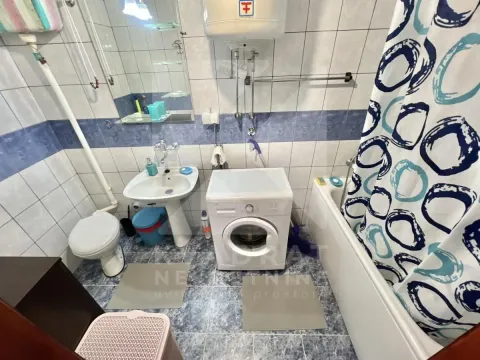 Bathroom equipped with sanitary fixtures, a bathtub, and a washing machine. - image 10