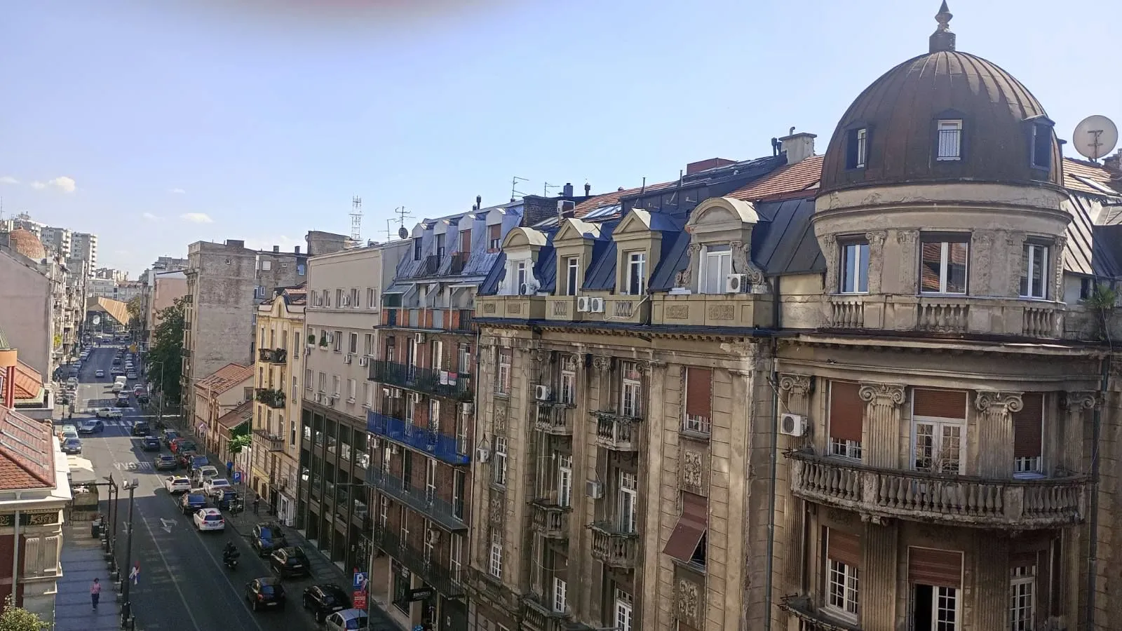Pogled sa terase na gradsku ulicu i okolne fasade starih zgrada.