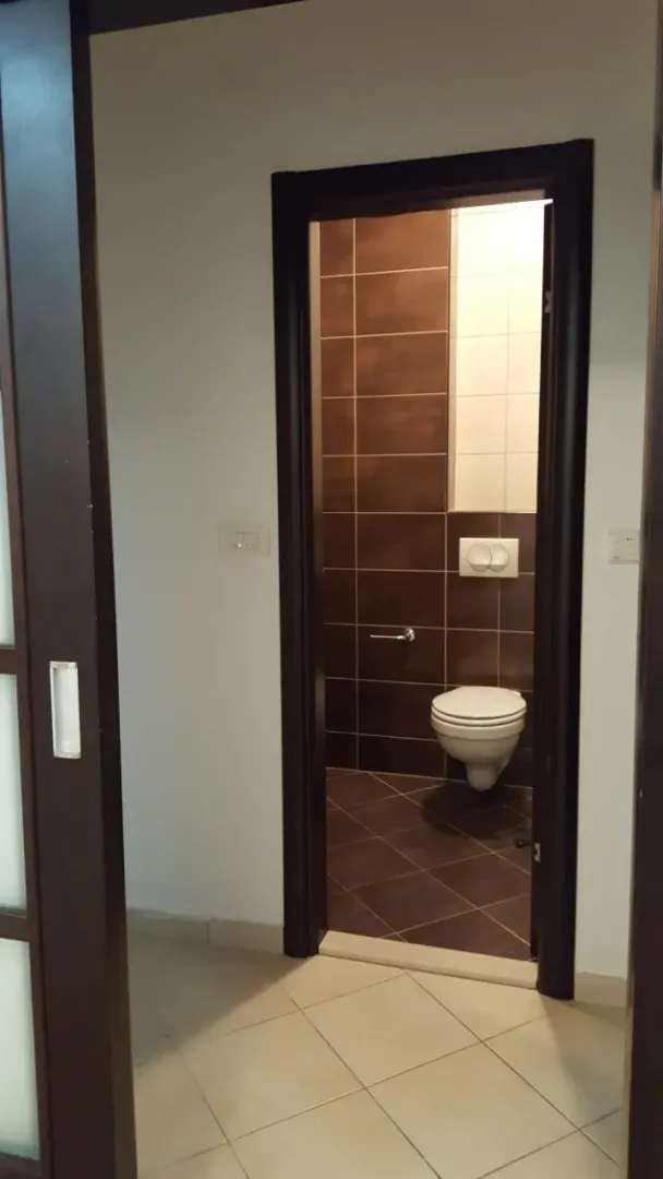 View of a bathroom with a toilet through an open door.