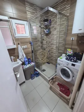 Bathroom equipped with a shower cabin, washbasin, and washing machine. - image 7