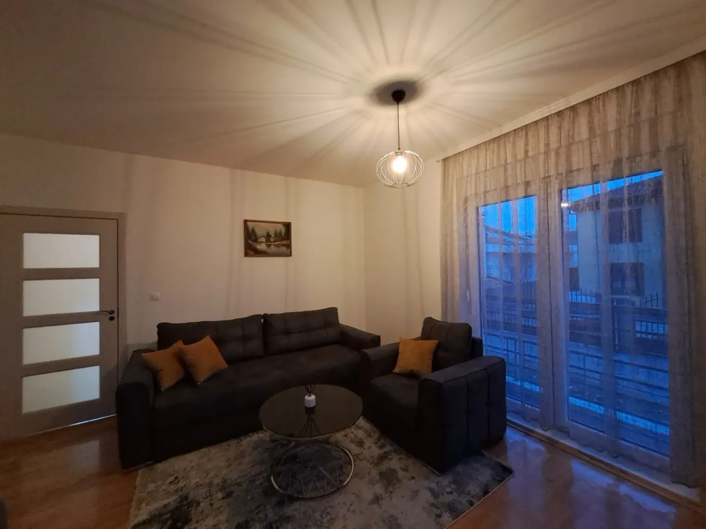 Living room with dark furniture and large glass doors.