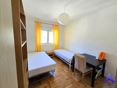 Spavaća soba sa dva kreveta, radnim stolom i policom. - image 11