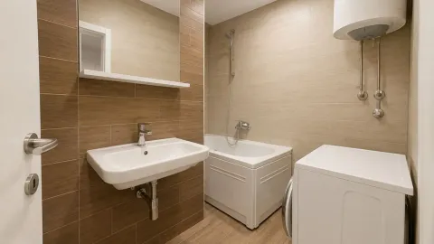 Kupatilo opremljeno umivaonikom, kadom, ogledalom i mašinom za veš. - image 6