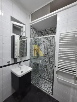 Moderno kupatilo sa tuš kabinom, umivaonikom i belim pločicama. - image 11