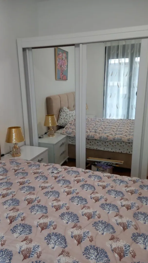 Bright bedroom featuring a large built-in wardrobe with mirrored doors.