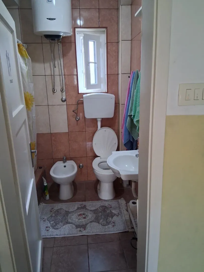 Smaller bathroom with sanitary ware and brown-toned tiles.