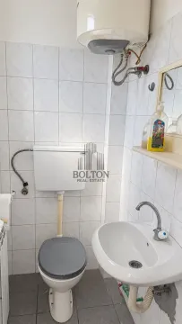 Smaller bathroom with a toilet, washbasin, and water heater. - image 5