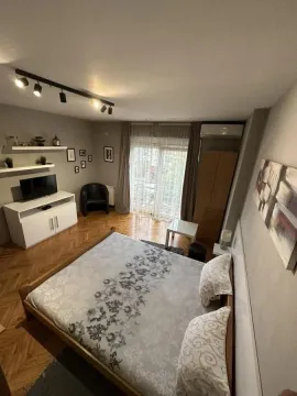 Nameštena spavaća soba sa bračnim krevetom, TV-om i izlazom na terasu. - image 3