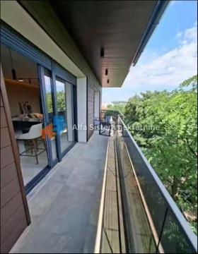 Spacious covered balcony with glass railing and green view. - image 3