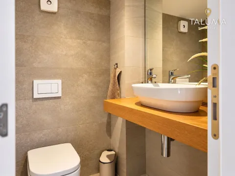 Modern bathroom with a sink on a wooden shelf and a toilet. - image 11
