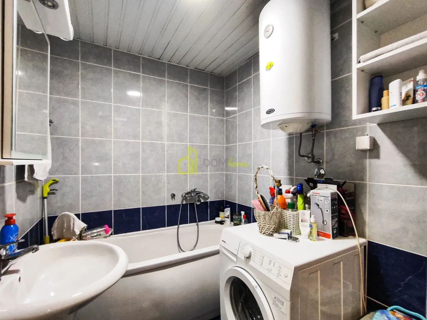 Bathroom equipped with a bathtub, washbasin, washing machine, and water heater.