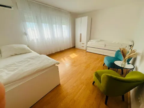 Svjetla i prostrana spavaća soba sa dva kreveta, garderoberom i garniturom za sjedenje. - image 9