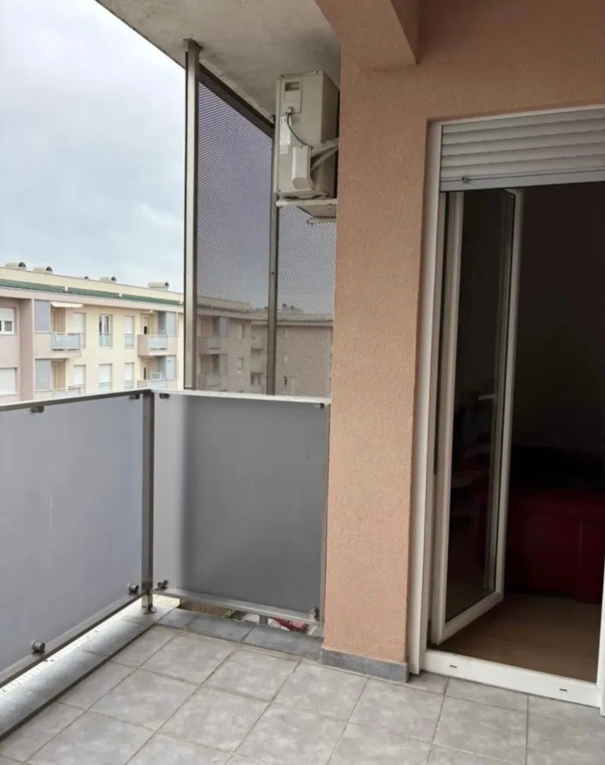 Natkriveni balkon sa popločanim podom i zaštitnom ogradom.